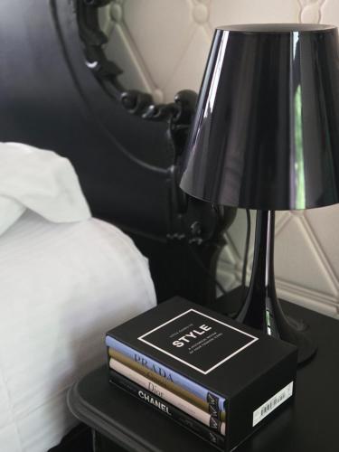 a stack of books sitting on a table next to a lamp at Château de Courtebotte in Saint-Jean-de-Blaignac