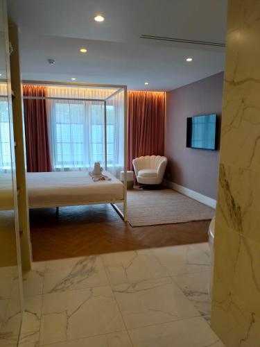 a room with a bed and a couch and a window at Van Der Valk Hotel Brugge Oostkamp in Oostkamp