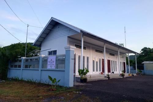 a white and blue building with a lot of windows at Phnom Sampov Homestay ផ្ទះលំហែភ្នំសំពៅ in Phumĭ Kdaông Khang Tbong