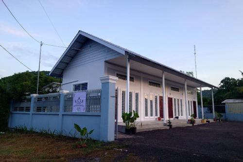 a white building with a blue at Phnom Sampov Homestay ផ្ទះលំហែភ្នំសំពៅ in Phumĭ Kdaông Khang Tbong