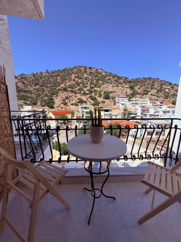 a table and chairs on a balcony with a view at Argiro's apartment at Agia Galini in Agia Galini