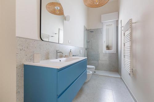 Un baño azul con lavabo e inodoro. en Nana' by BarbarHouse, en Marina di Mancaversa