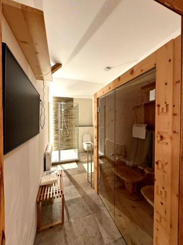 a bathroom with a glass walled shower and a toilet at ZumHubertus in Bschlabs