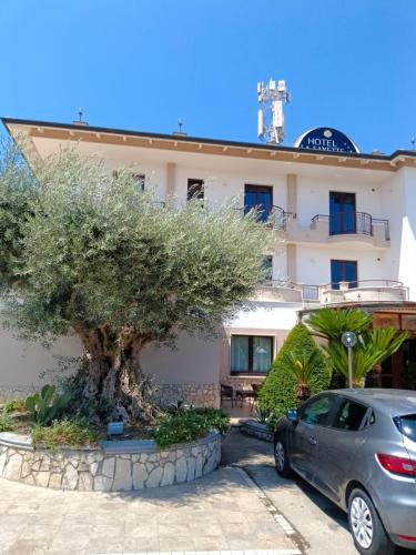a car parked in front of a building with a tree at Hotel La Fayette Giugliano Licola in Giugliano in Campania