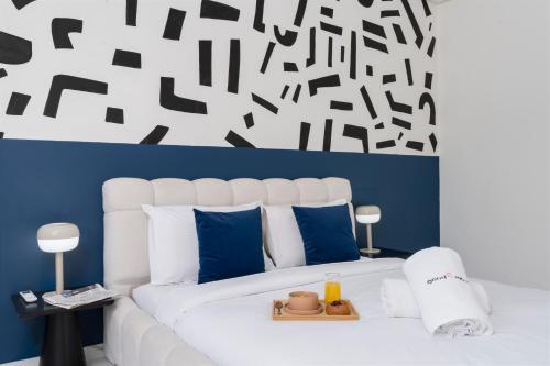 a bedroom with a large white bed with blue pillows at The lodge Residence by Goodmove - Hay Riad in Rabat