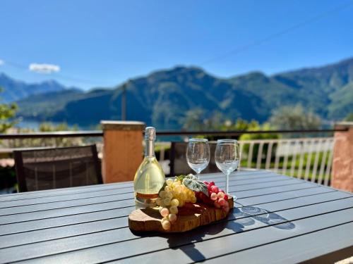 a table with a bottle of wine and two glasses at Casetta Rossa in Mezzegra