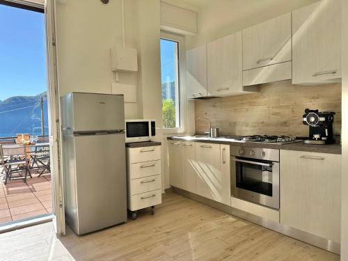 a kitchen with a stainless steel refrigerator and a balcony at Casetta Rossa in Mezzegra