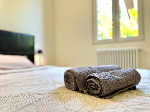 two towels sitting on top of a bed at Casetta Rossa in Mezzegra