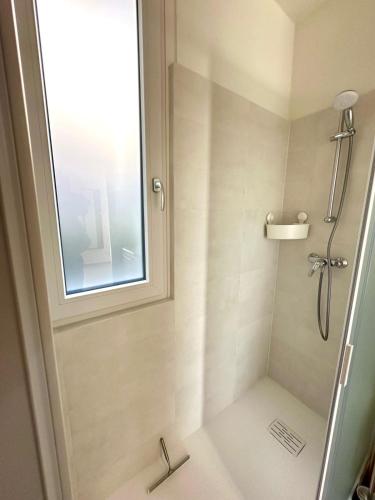 a bathroom with a shower with a window at Casetta Rossa in Mezzegra
