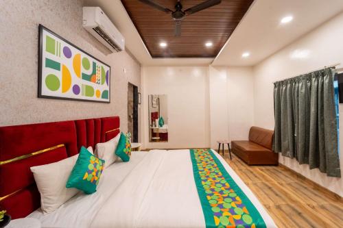 a bedroom with a large bed and a couch at Hotel Vedic Vista in Indore