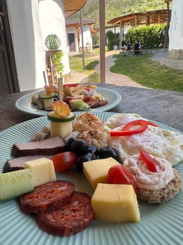 a plate of food with sausage and cheese on a table at Cob Village in Berca