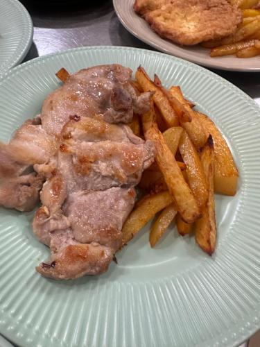 a plate of food with french fries and meat at Cob Village in Berca