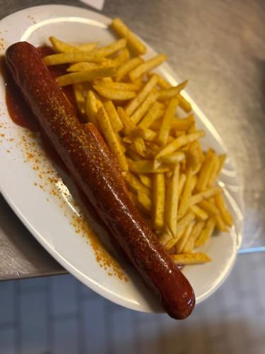 a plate with a hot dog and french fries at Boga's im Schützenhof Hüttenbusch in Worpswede