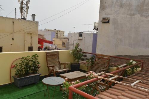 a balcony with chairs and a table on a building at Appartement aux Mamelles in Dakar