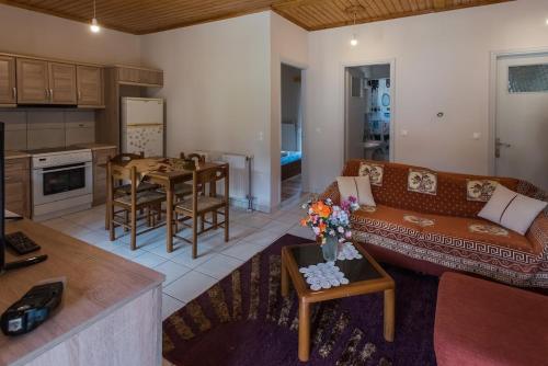 a living room with a couch and a table at ΥΠΕΡΟΧΟ ΣΠΙΤΙ ΜΕ ΘΕΑ ΣΤΟ ΝΕΟ ΔΕΡΜΑΤΙ Karpenisi in Karpenision