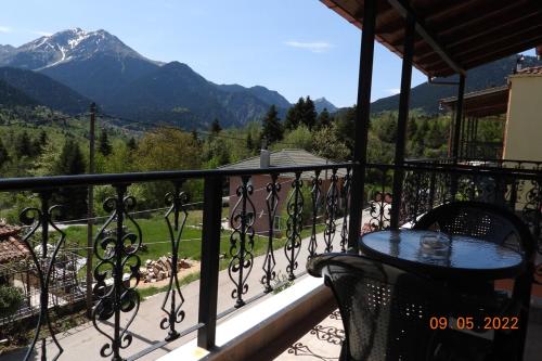 a balcony with a table and a view of a mountain at ΥΠΕΡΟΧΟ ΣΠΙΤΙ ΜΕ ΘΕΑ ΣΤΟ ΝΕΟ ΔΕΡΜΑΤΙ Karpenisi in Karpenision
