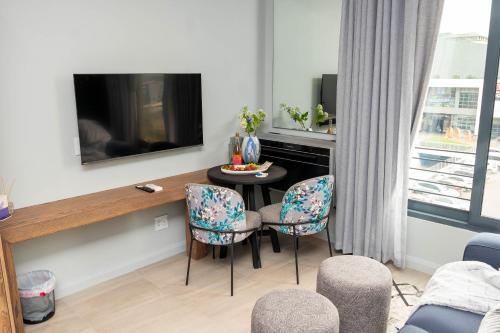 a living room with a table and chairs and a tv at Triple M Luxury in Vosburg