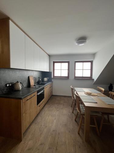 a kitchen with a table and a dining room at Apartmán Hájenka - Makov in Makov