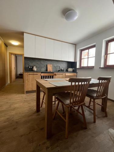 a kitchen with a table and chairs in a room at Apartmán Hájenka - Makov in Makov