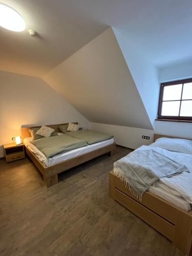 a bedroom with two beds and a window at Apartmán Hájenka - Makov in Makov