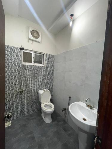 un baño con inodoro y lavabo en Cozy and Peaceful 2 Bedroom Luxury Apartment, en Multán