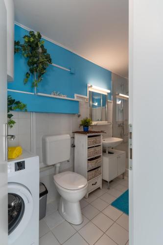 a bathroom with a white toilet and a sink at Sunset in Kustići