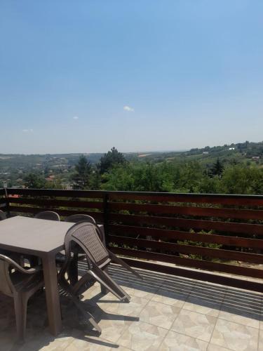 a table and chairs on a balcony with a view at Miličin konak in Vrdnik