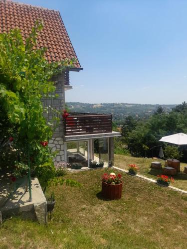 a house with a bench and flowers in a yard at Miličin konak in Vrdnik