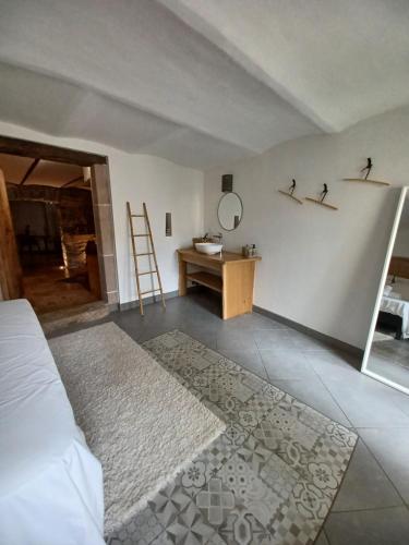 a bedroom with a bed and a table and a mirror at Hébergement insolite avec jacuzzi privatif Millau in Millau