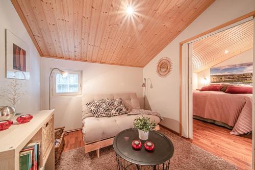 a living room with a couch and a bed at Lomavuokra Levi Central Kätkä Kaksi in Levi
