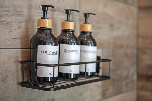 a group of bottles on a shelf in a bathroom at La Douce Pomme in Saint-Pierre