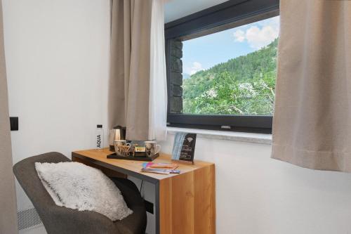 a room with a chair and a table with a window at La Douce Pomme in Saint-Pierre