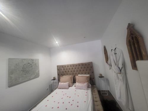 a small white bedroom with a bed in it at Le conviviale in Belfort