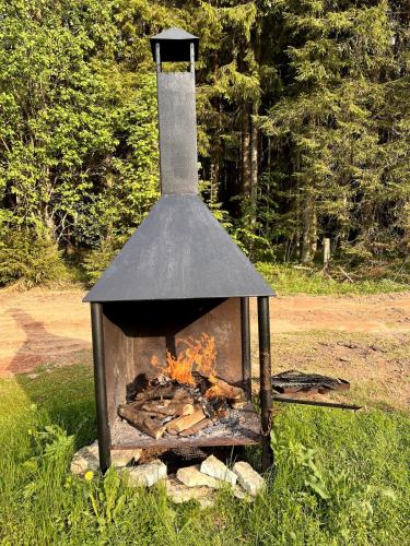 an outdoor stove with a fire in a field at Nature Reserve Hideaway 