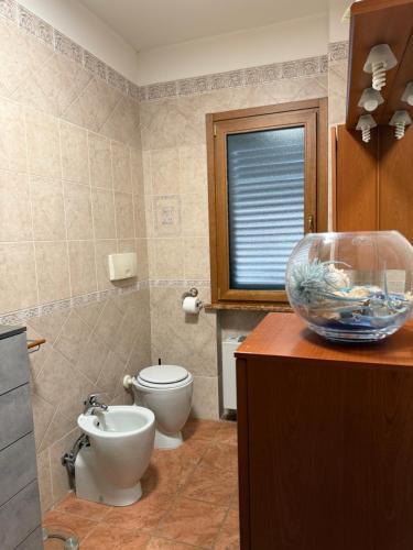 a bathroom with a toilet and a fish bowl on a counter at Appartamenti Venezia in Termoli