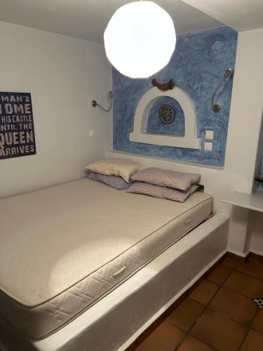 a bed in a room with a light above it at Serifos house in Serifos Chora