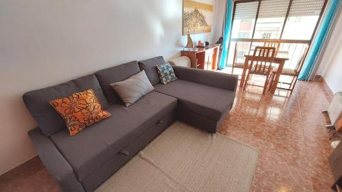 a living room with a gray couch with pillows at Enjoy Lisbon Cascais Sintra 1200 metres to metro blue line Sintra Rail line Free Parking in Amadora