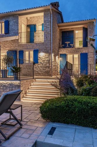 a building with blue doors and stairs in front of it at Villa Sterpazzi - near Porec with Sea View, private Jacuzzi, Sauna and Pool in Višnjan