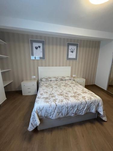 a bedroom with a bed and two pictures on the wall at El Coso in Santa Cruz de la Zarza