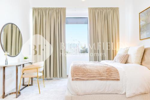 une chambre avec un lit, un bureau et un miroir dans l'établissement Bloomfields Cozy 1br Mayan with Beach Access, à Abu Dhabi