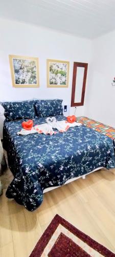 a bedroom with a bed with a blue bedspread at Mouton Blanc Campos do Jordão in Campos do Jordão