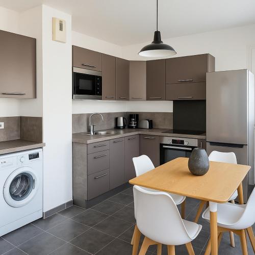 - une cuisine avec une table en bois et des chaises blanches dans l'établissement APPARTEMENT T3 65 m2 CENTRE VILLE, à Porto-Vecchio