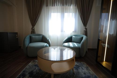 a living room with two chairs and a coffee table at Gold Palace Hotel in Cairo