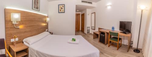 a hotel room with a bed and a desk and a television at Pacoche Murcia in Murcia