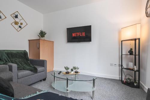 a living room with a couch and a table at Trafford Stays in Manchester