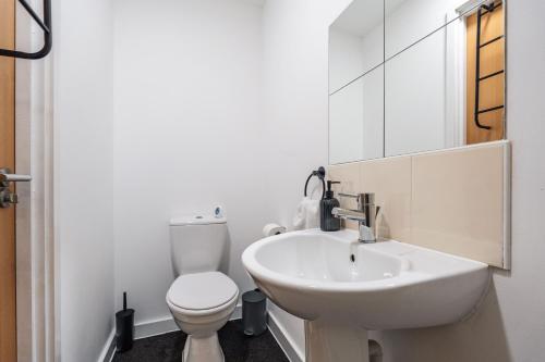 a white bathroom with a sink and a toilet at Trafford Stays in Manchester