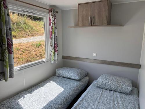 a small room with a bed and a window at Camp Les Deux in Jouillat