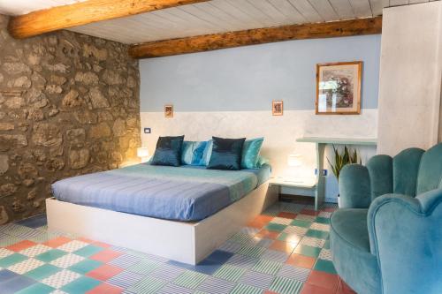 a bedroom with a bed and two blue chairs at Collina Blu in Orvieto