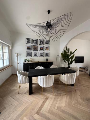 une salle à manger avec une table noire et des chaises blanches dans l'établissement Maison de 140m2 à 300m de la plage, à Dunkerque