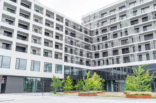 a large white building with trees in front of it at Work&Living Studio-Prístavná1 in Nivy